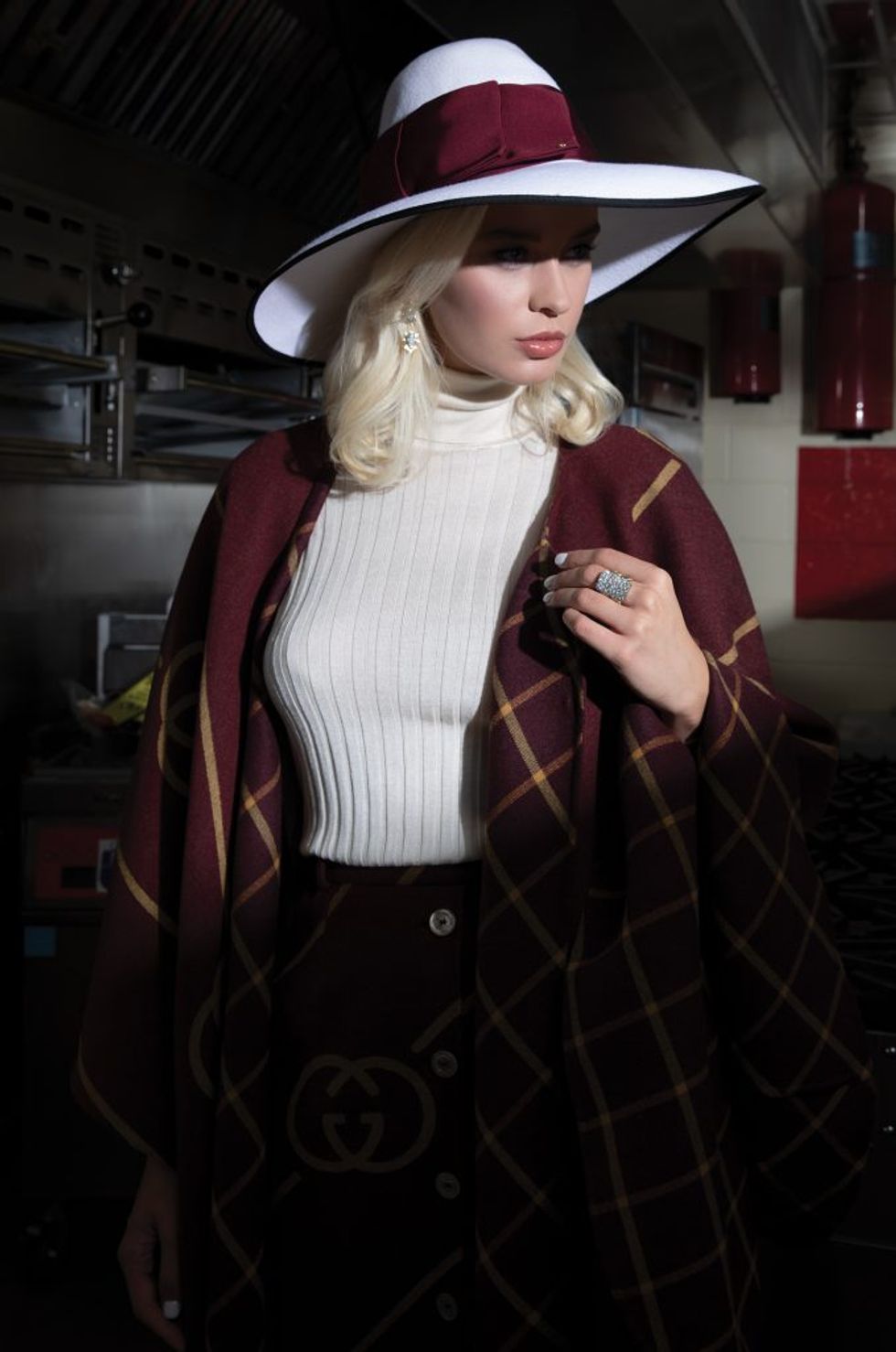 Silk turtleneck top, $1,100, double-window GG diagonal asymmetric cape, $4,800, and felt hat, $1,090, all by Gucci; earrings, $85,000, and ring, $25,625, both at Lesley Ann Jewels.