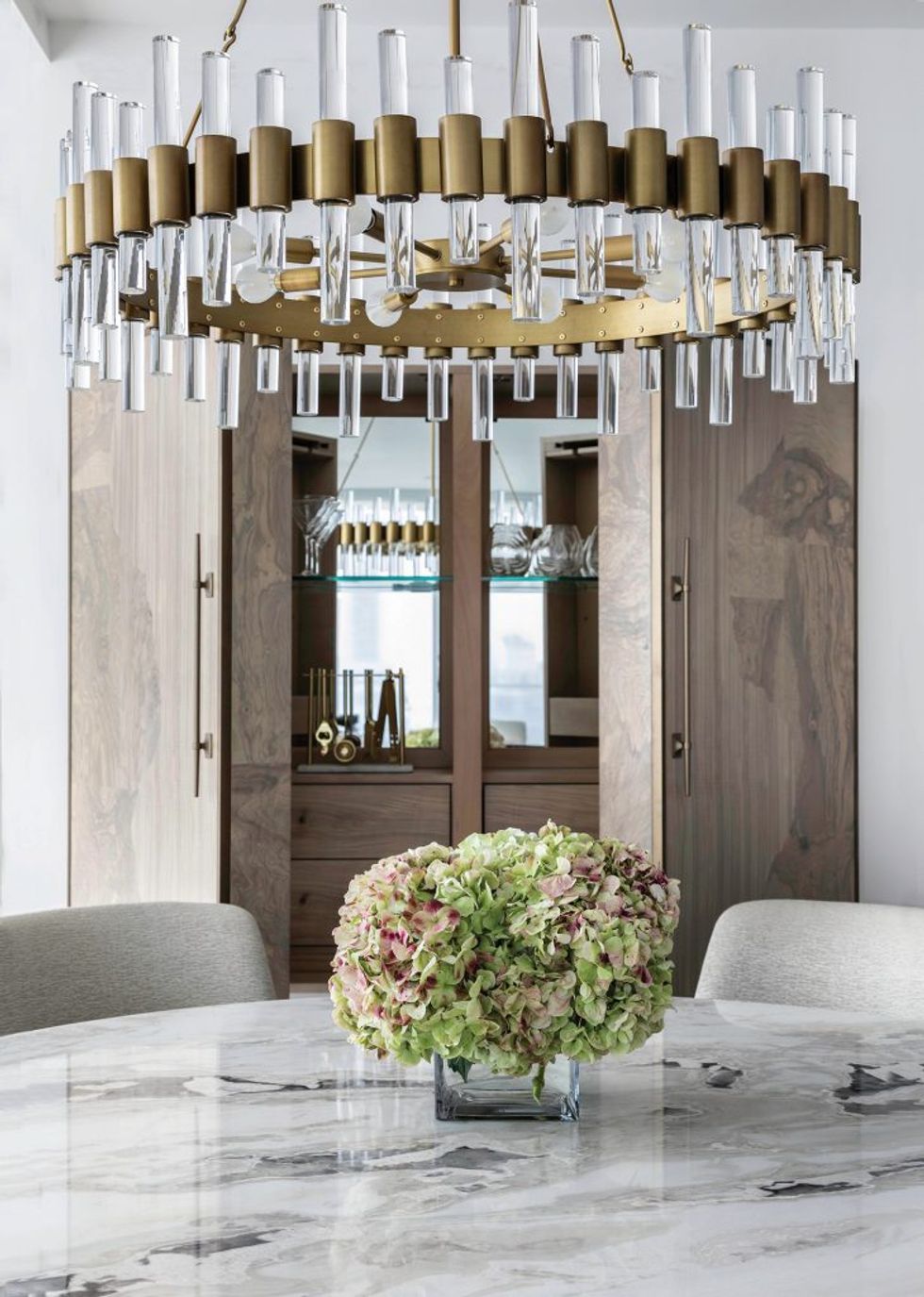 The dining room features an Aria Stone marble-topped table and custom oversize chairs