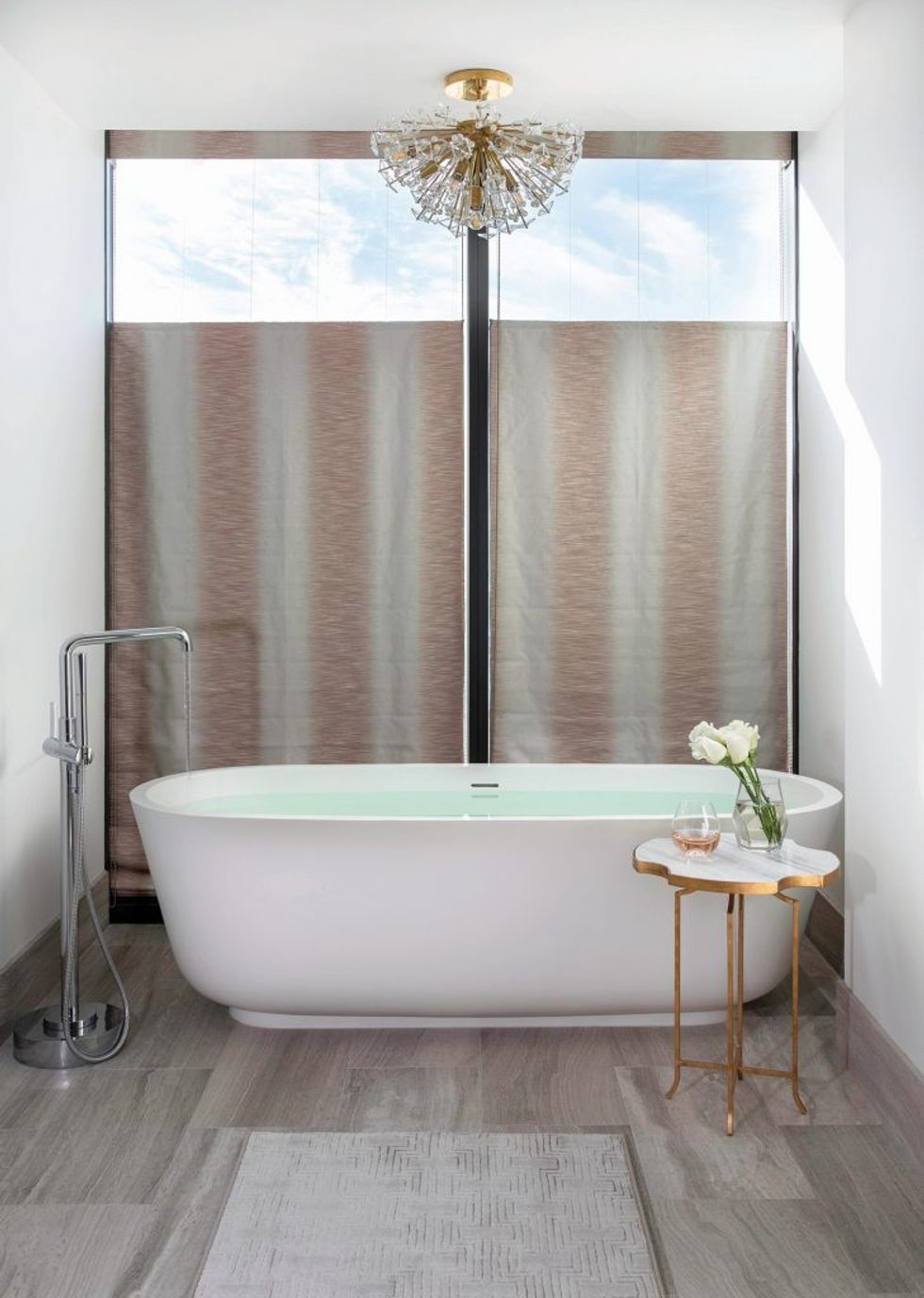 In the master bathroom, a top-down shade in Jane Churchill fabric lets in natural light while offering privacy