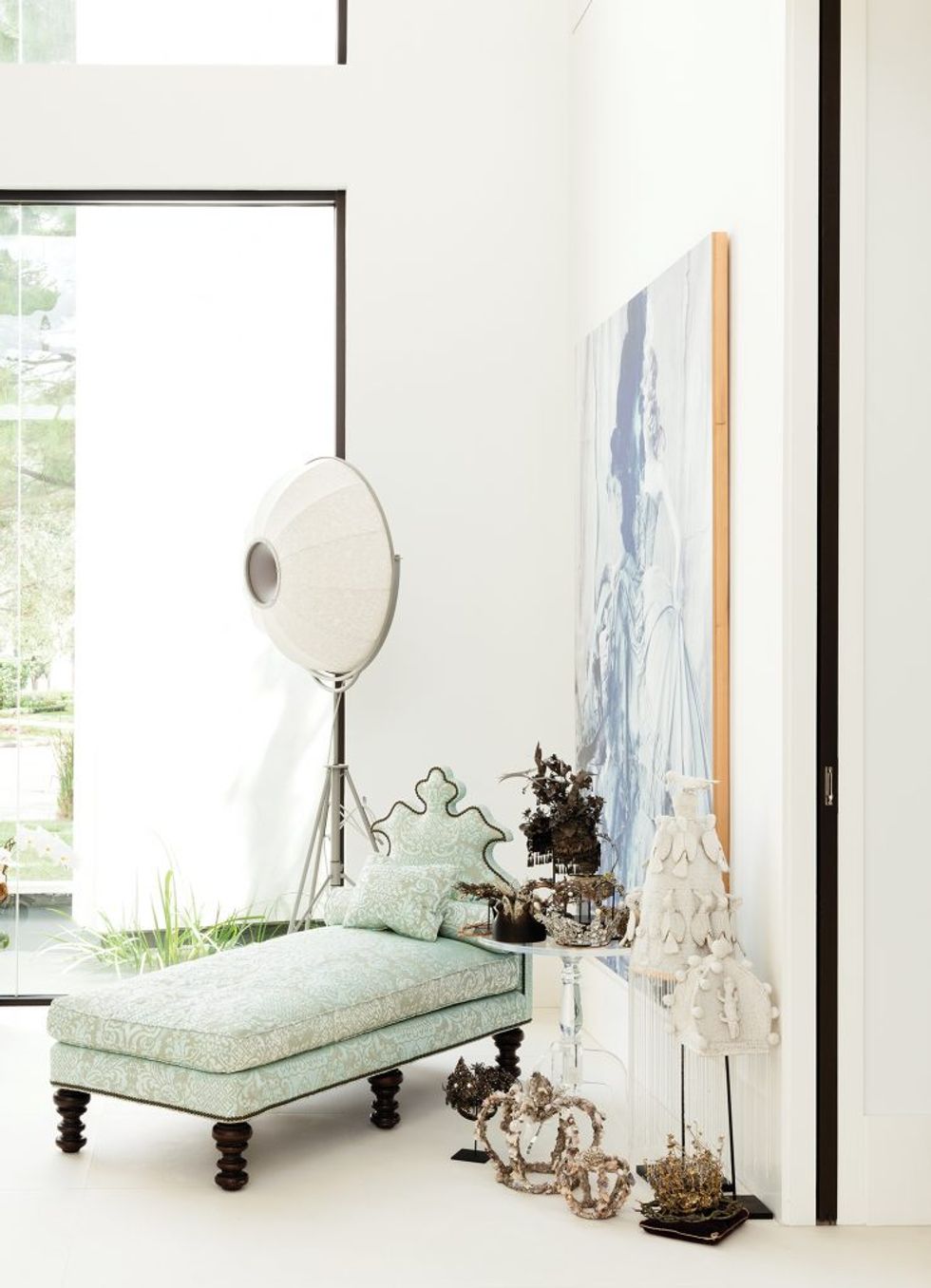 A seating area in the living room features a mint-green chaise and a Susy Gomez painting