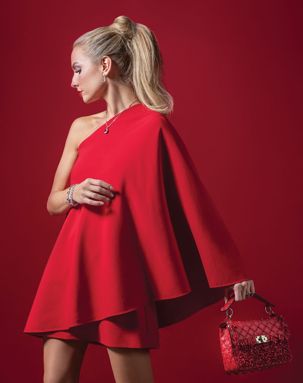 Dress and handbag, both by Valentino; ruby tennis bracelet, $41,838, by Vander Dys Collection, earrings, $18,238, bracelet, $30,650, diamond and pink sapphire chain, $3,125, with pendant, $10,700, and ring, $16,088, all by Charles Krypel at Vander Dys Fine Jewelers. 