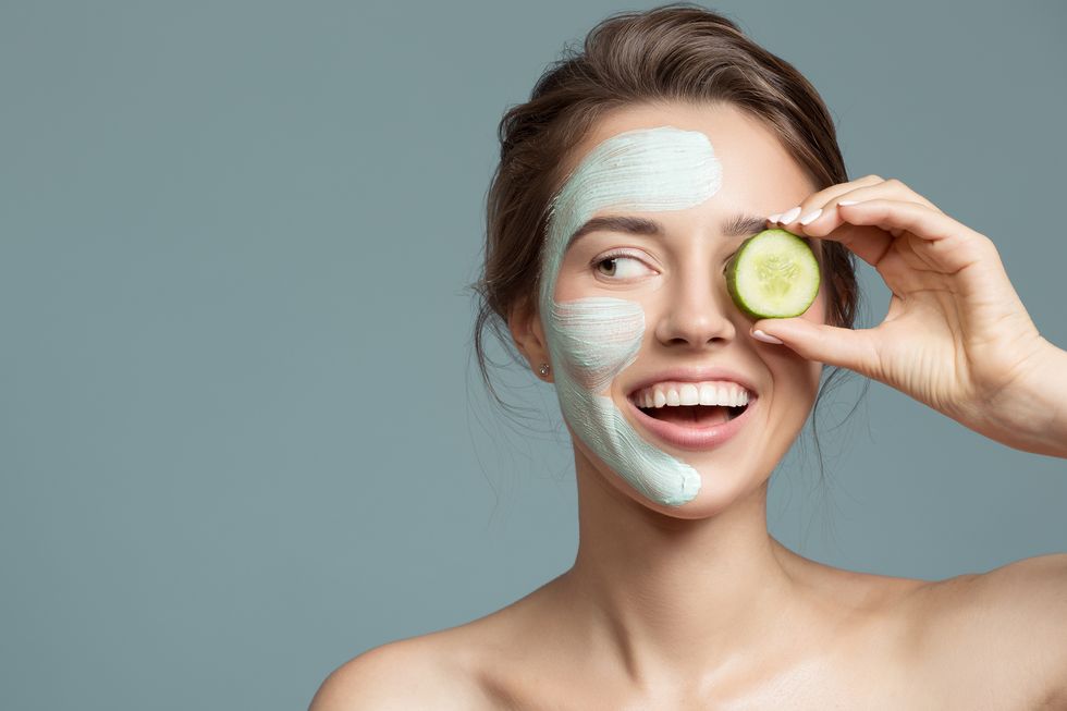 Portrait of beautiful woman with blue cream mask on her face.