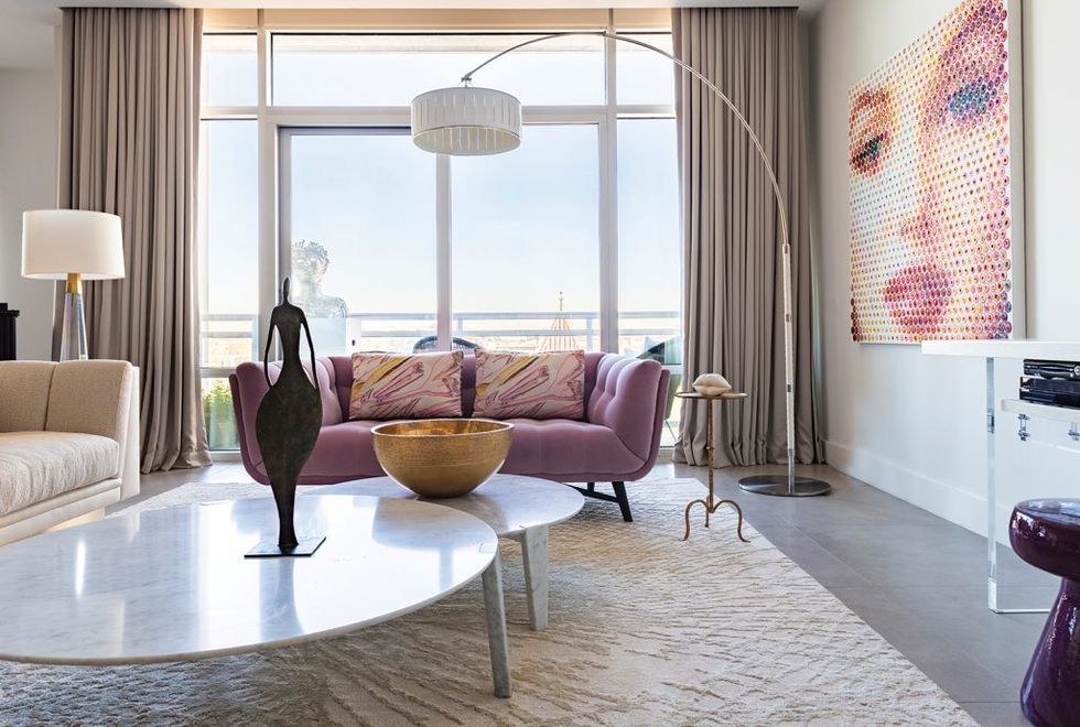 Focal points of Rathe’s light-filled living room include a purple Roche Bobois sofa, a pixelated painting of Marilyn Monroe by Gavin Rain, and stunning floor-to-ceiling drapes from Creations Metaphores.
