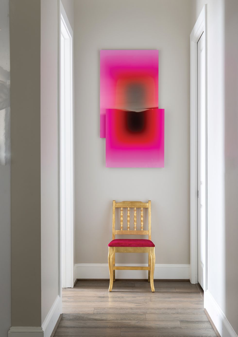 A pink acrylic floating panel hangs above a vintage chair that was redesigned by Pugh to become part of the art