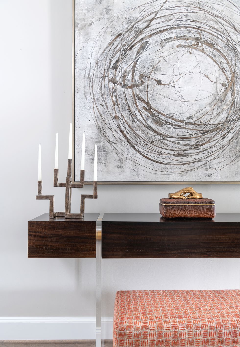 Gold-flecked art by Uttermost and a wood-and-acrylic table sit in the entryway