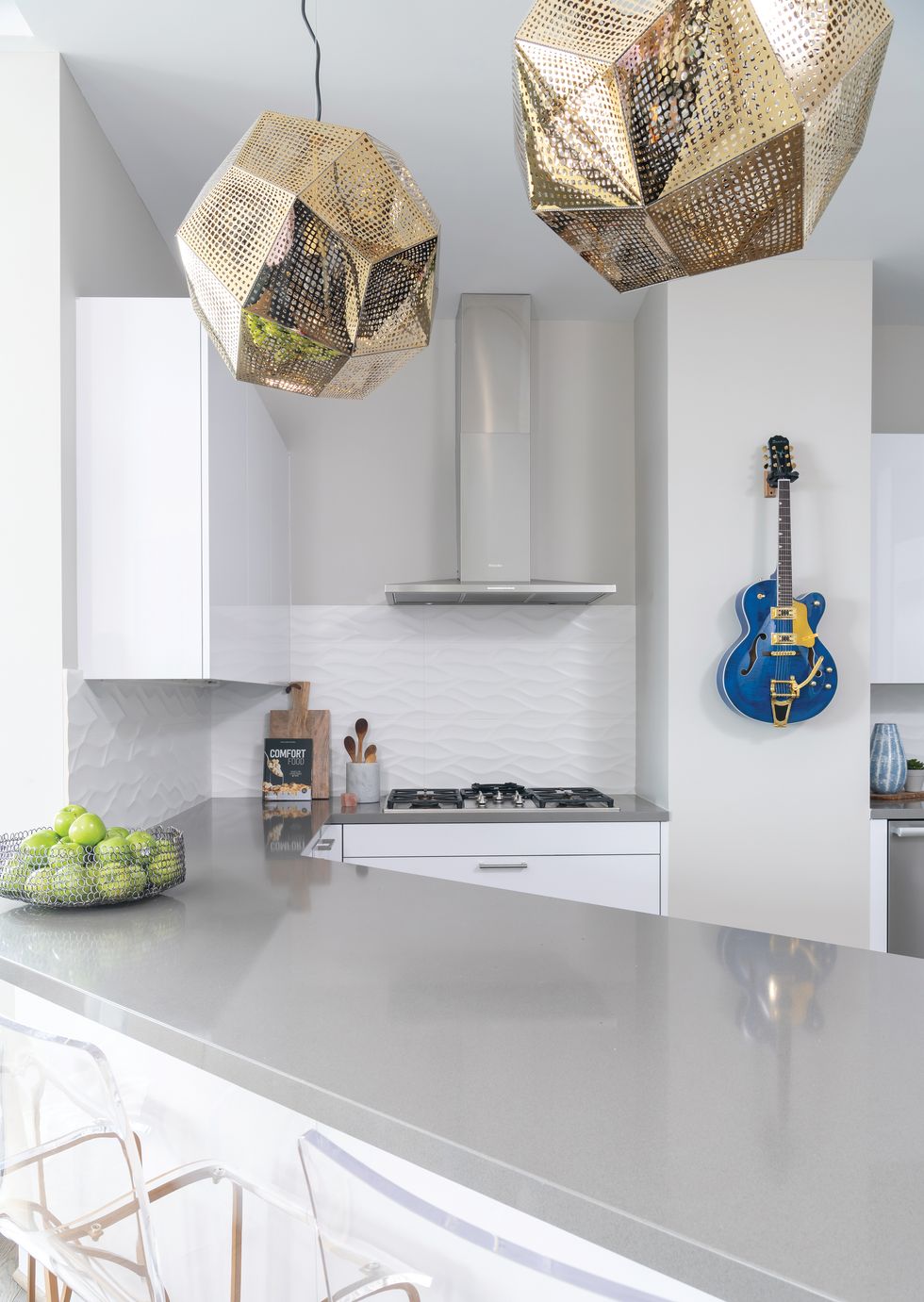 In the kitchen, a high-gloss blue electric guitar and pendant lighting from Avenue serves as art