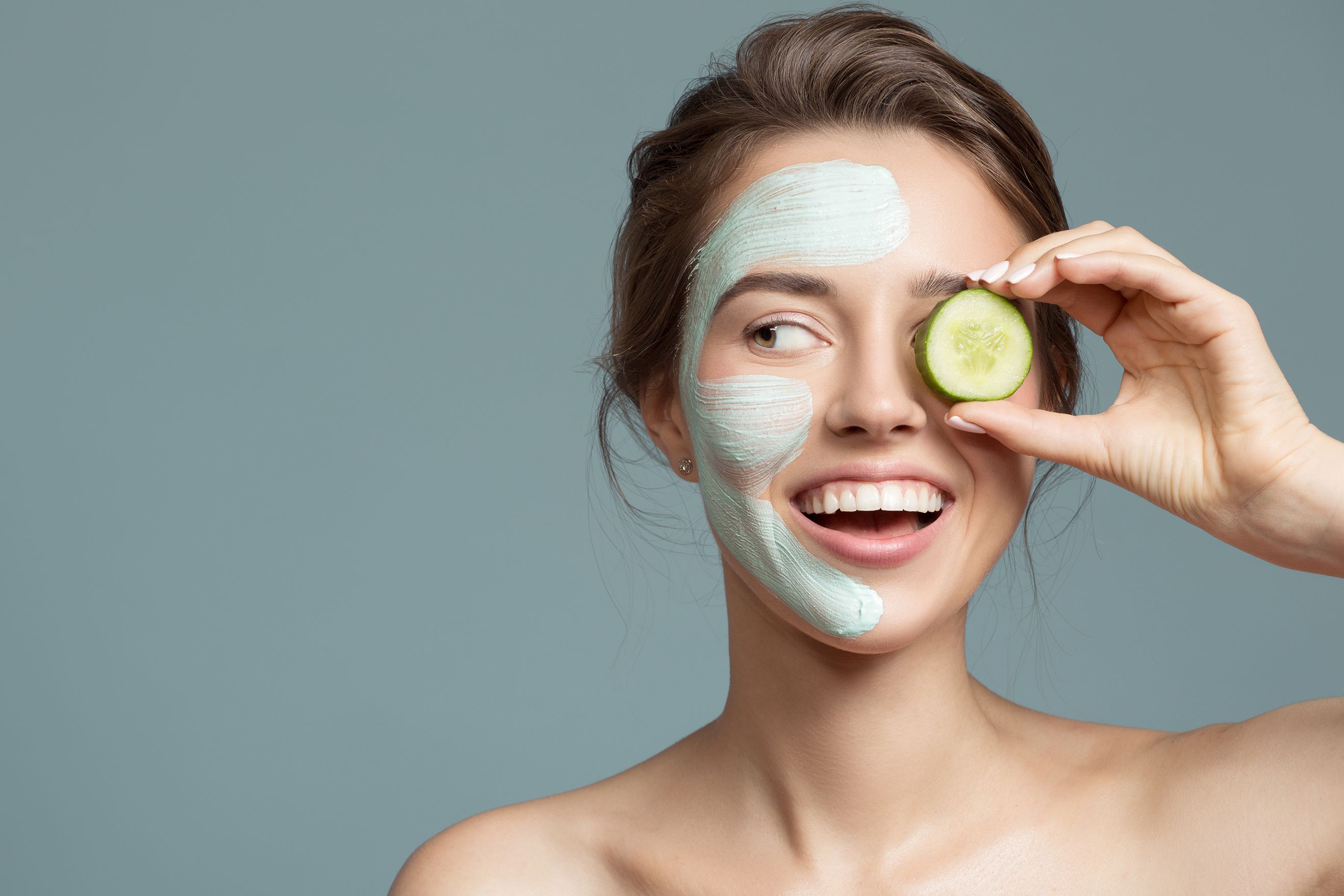 Portrait of beautiful woman with blue cream mask on her face.